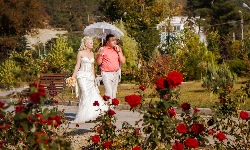 свадебный фотограф снимает свадебную прогулку жениха и невесты у озера Абрау
