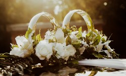 фотография свадебных колец на свадебной машине в лучах заката