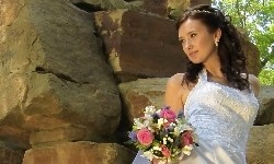 фотограф фотографирует невесту на скале в старом парке в Кабардинке